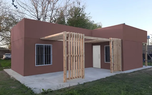 Vivienda Wood Frame color bordo con galería y columnas de madera, llave en mano zona sur GBA