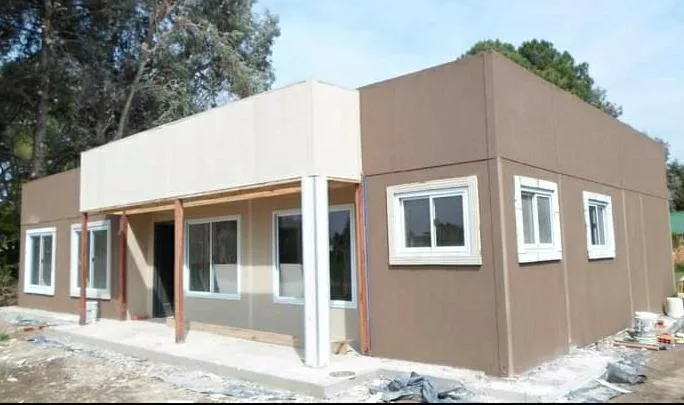 Casa Wood Frame amplia de dos cuerpos color arena con ventanales y galería techada